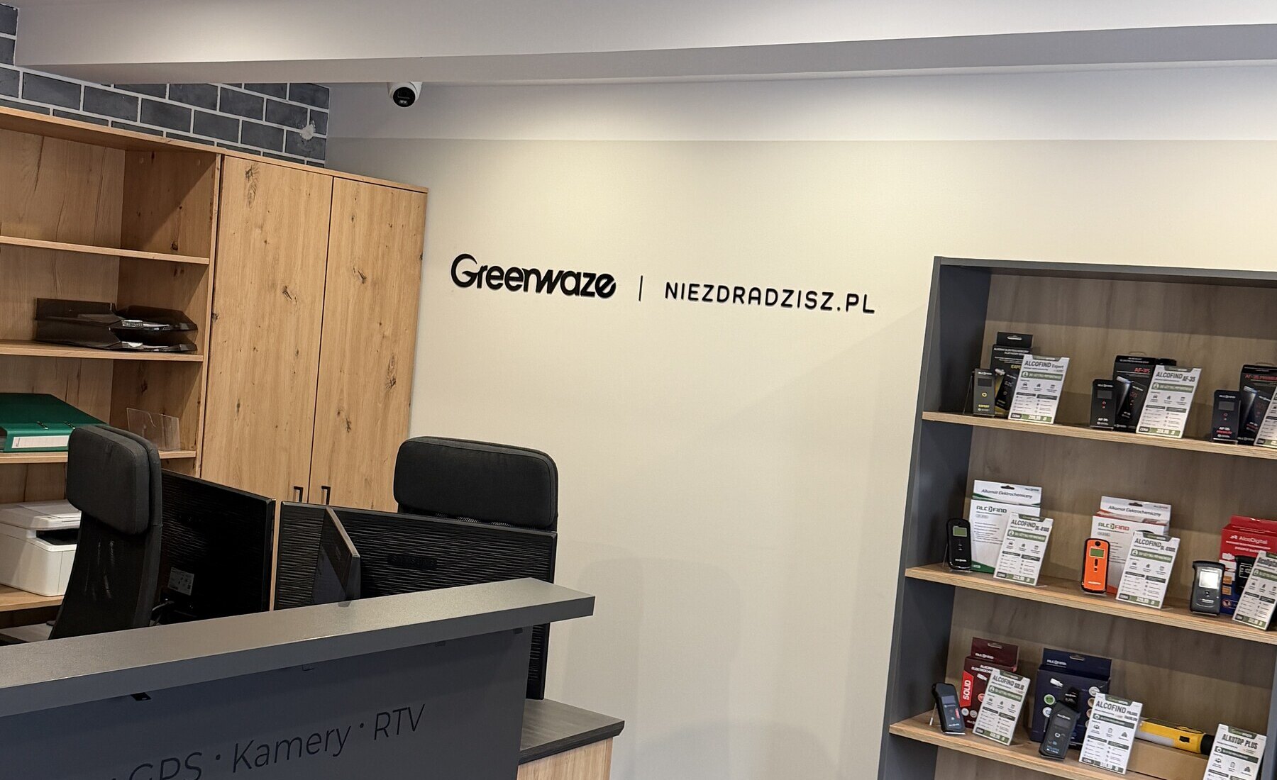 Punkt obsługi Greenwaze z ladą, logo i ekspozycją alkomatów