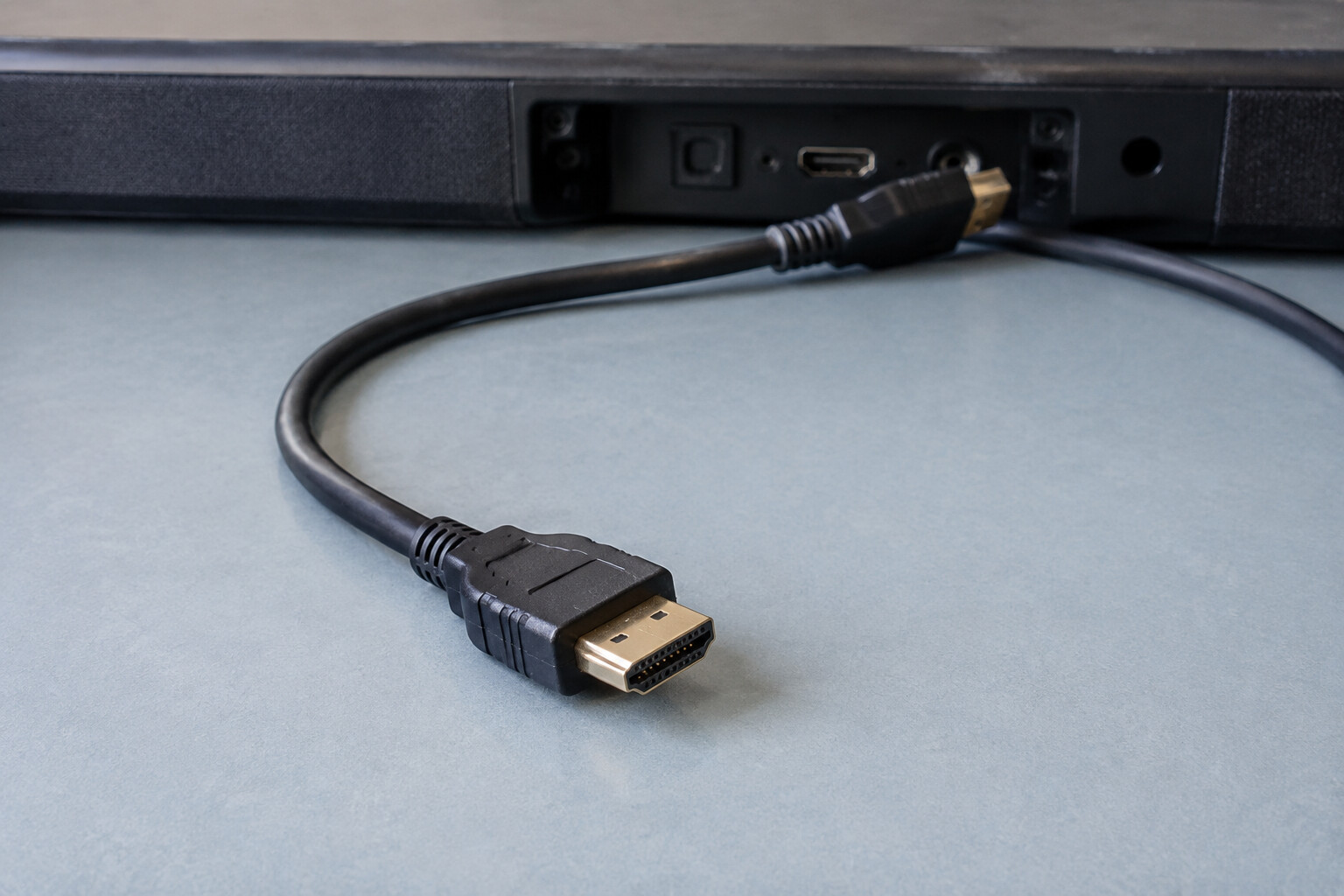 Wtyczka przewodu HDMI obok tylnego panelu soundbara