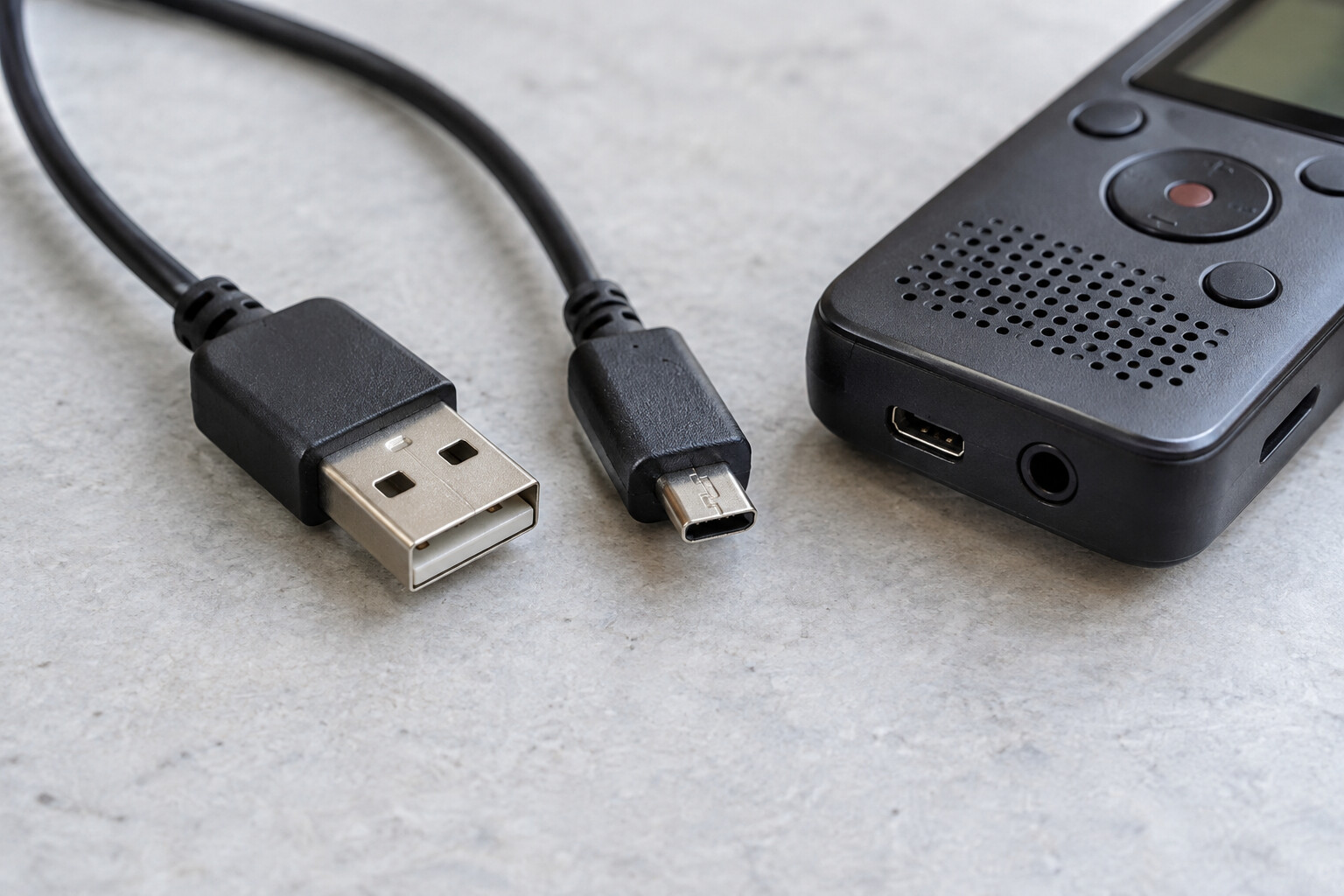 Końcówki przewodu USB obok przenośnego dyktafonu